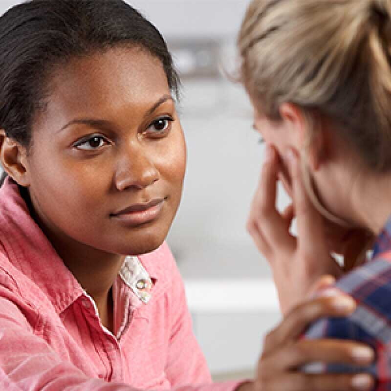 Young African American counselor comforting a female client.
