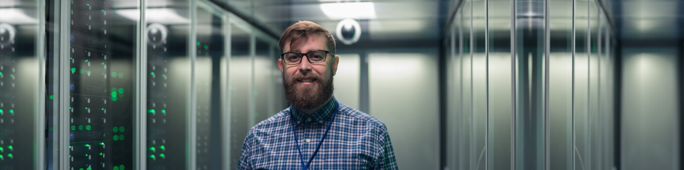 Male professional stands in server room