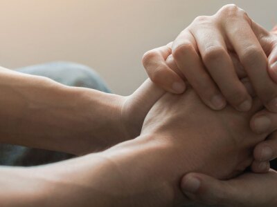 Counselor sitting and touch hand young asian man near window.