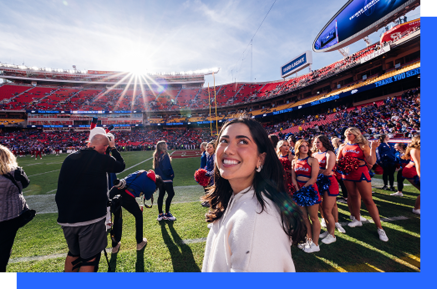 Smiling young female student looks at the crowd in the stadium.