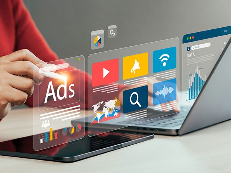 A person working on a marketing ad on a laptop.