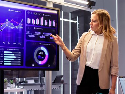 A group of people looking at data on a large computer screen.