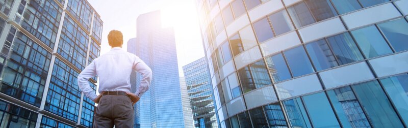 Business man stands downtown reflecting on his career options.