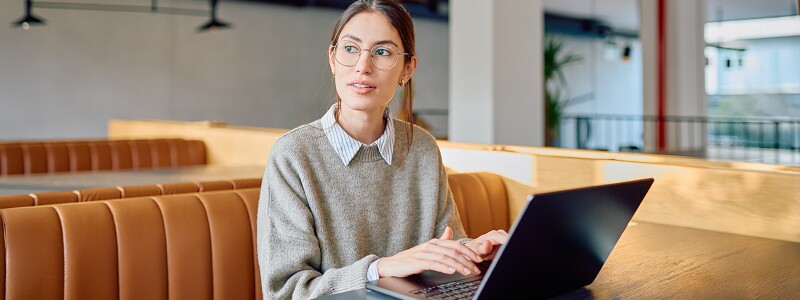 Online student working on her laptop in a cafe.