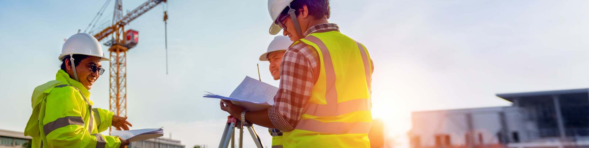 Three men around a land surveyor