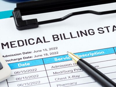 A medical billing statement, pen, and calculator