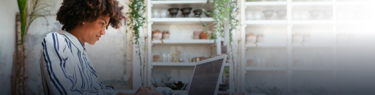 woman in striped blouse using a laptop