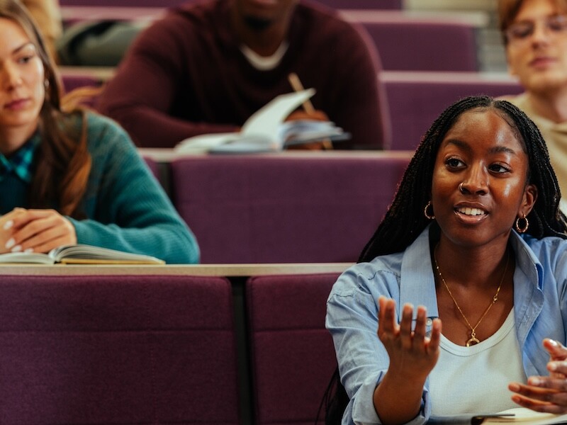 University student asking question during class in lecture hall