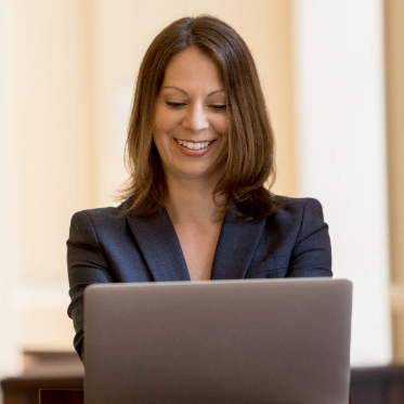 lady smiling while working on a laptop