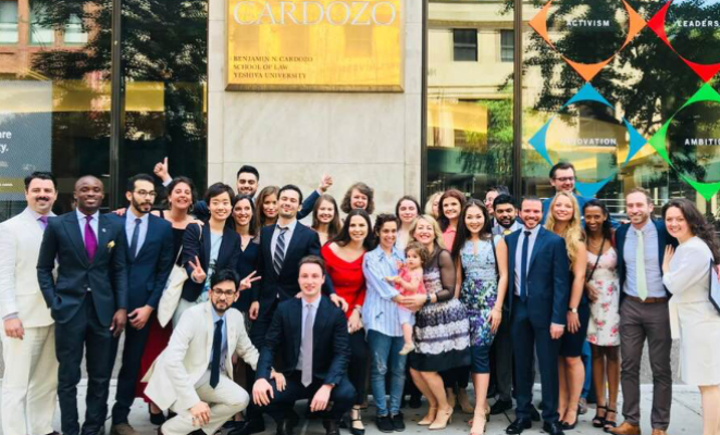 a group of students and faculty pose outside the Cardozo Law building