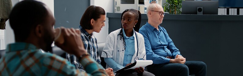 woman healthcare professional talking with man in a waiting room
