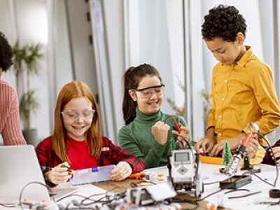 teacher working with four kids stem