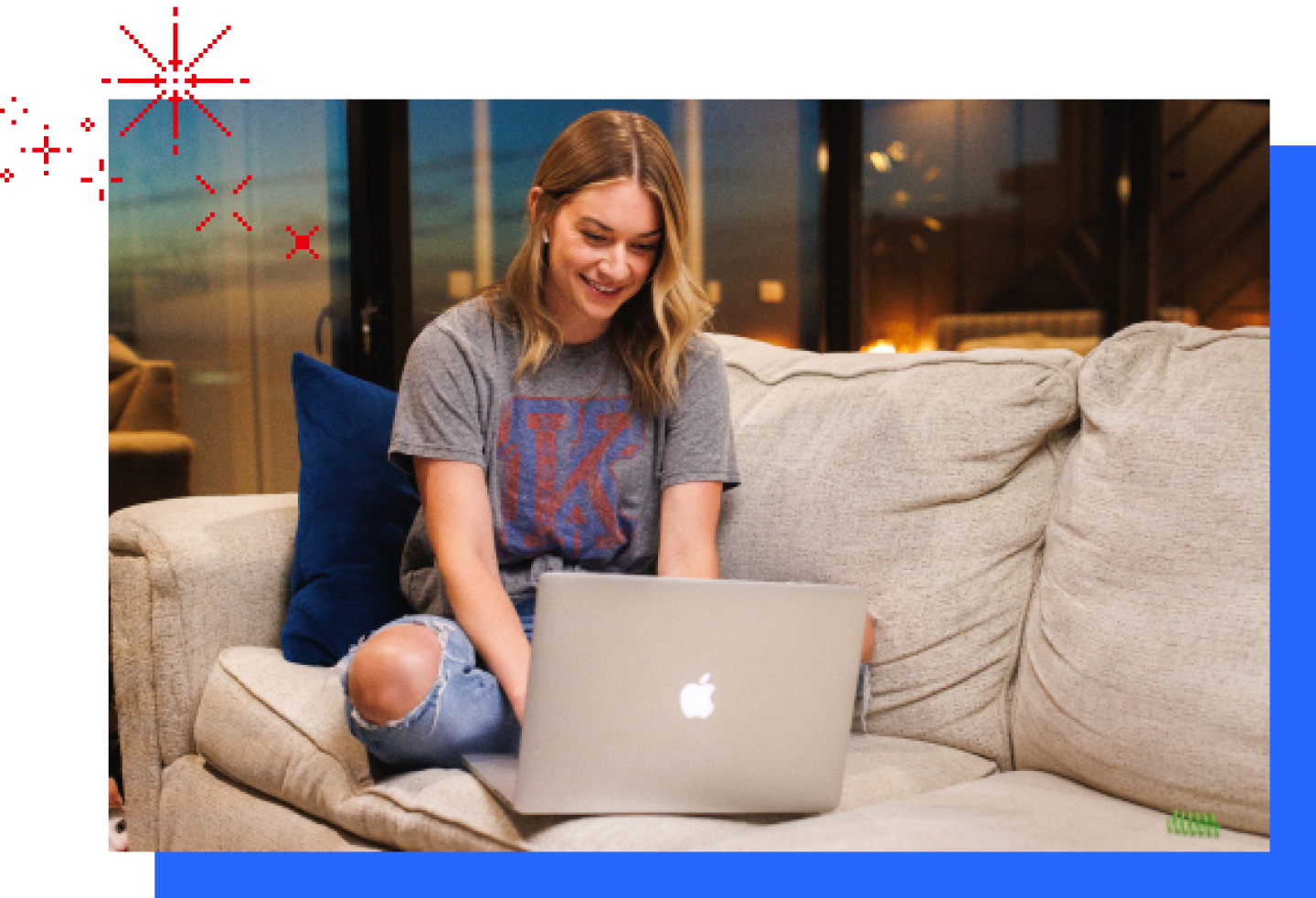 A female KU student reviews her Jayhawkville online lesson on a laptop while she sits on a couch.