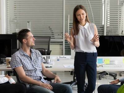 group sitting in office listening to woman in white shirt speaking