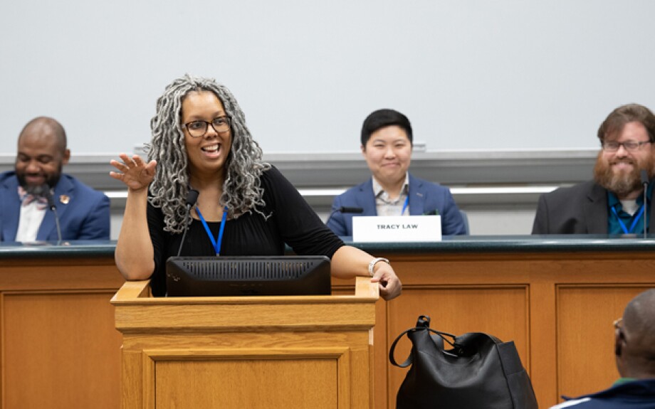 Saru Matambanadzo, senior director of online programs, addresses Immersion Weekend participants ahead of a topical panel discussion.