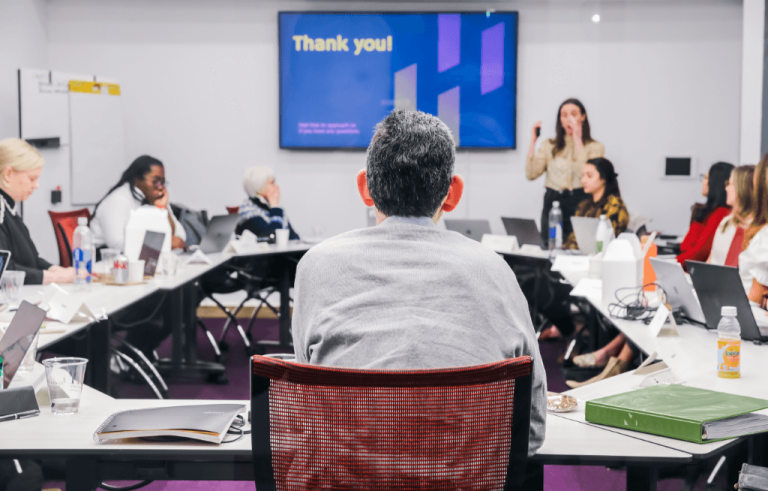Group of students seated facing each other in classroom setting