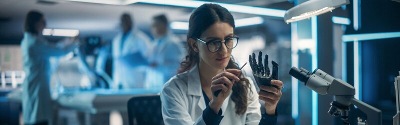 Biomedical engineer working on a robotic hand in a high-tech lab.