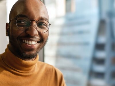 Millennial creative and trendy business entrepreneur smiling and looking away.