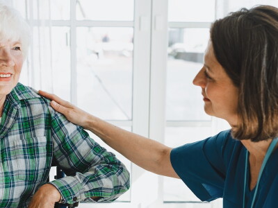 An allied health professional sits in conversation with her patient