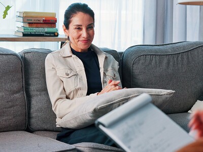 Patient on a sofa talking with her counselor.