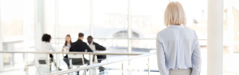 Rear view of nervous, middle-aged business woman applicant waiting for job interview