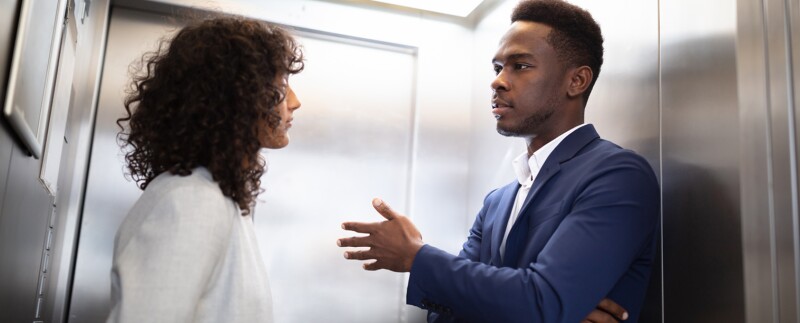 Businesspeople Having Conversation In Elevator