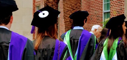 Group of graduates in caps and gowns entering commencement
