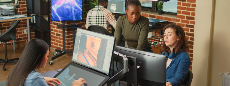 Diverse team of colleagues working on 3d engineering with multiple monitors.