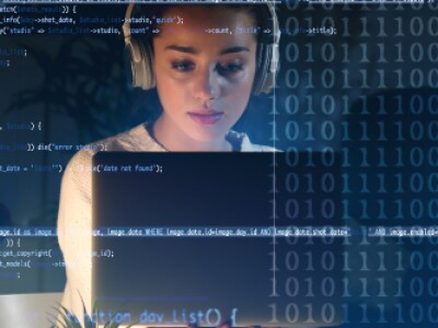 Woman wearing headphones working on laptop with data sets as overlay in foreground