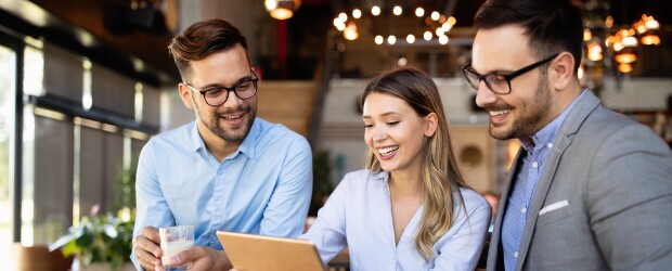 three people looking at a laptop screen