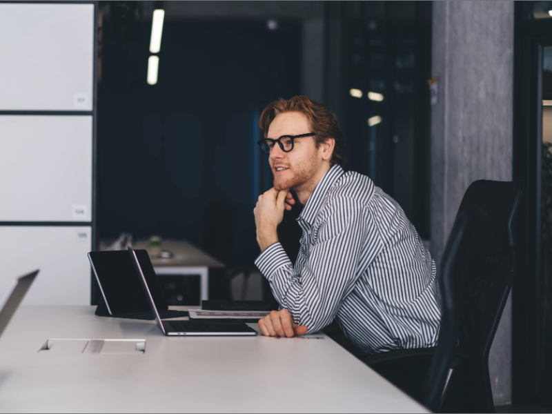 Smiling businessman discussing business with colleague in office