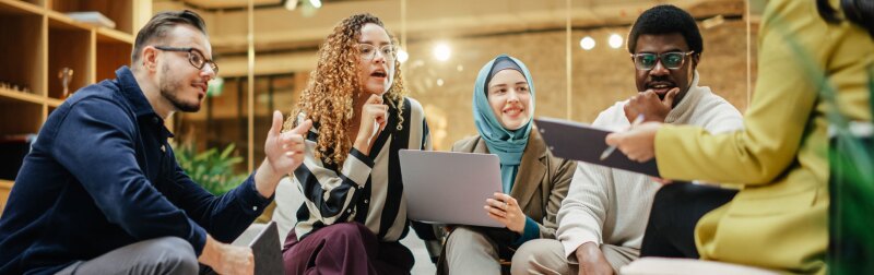 Wide Shot of a Multiethnic Group of People Discussing Ideas in a Meeting Room at Office.