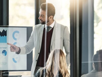 man pointing to screen with charts