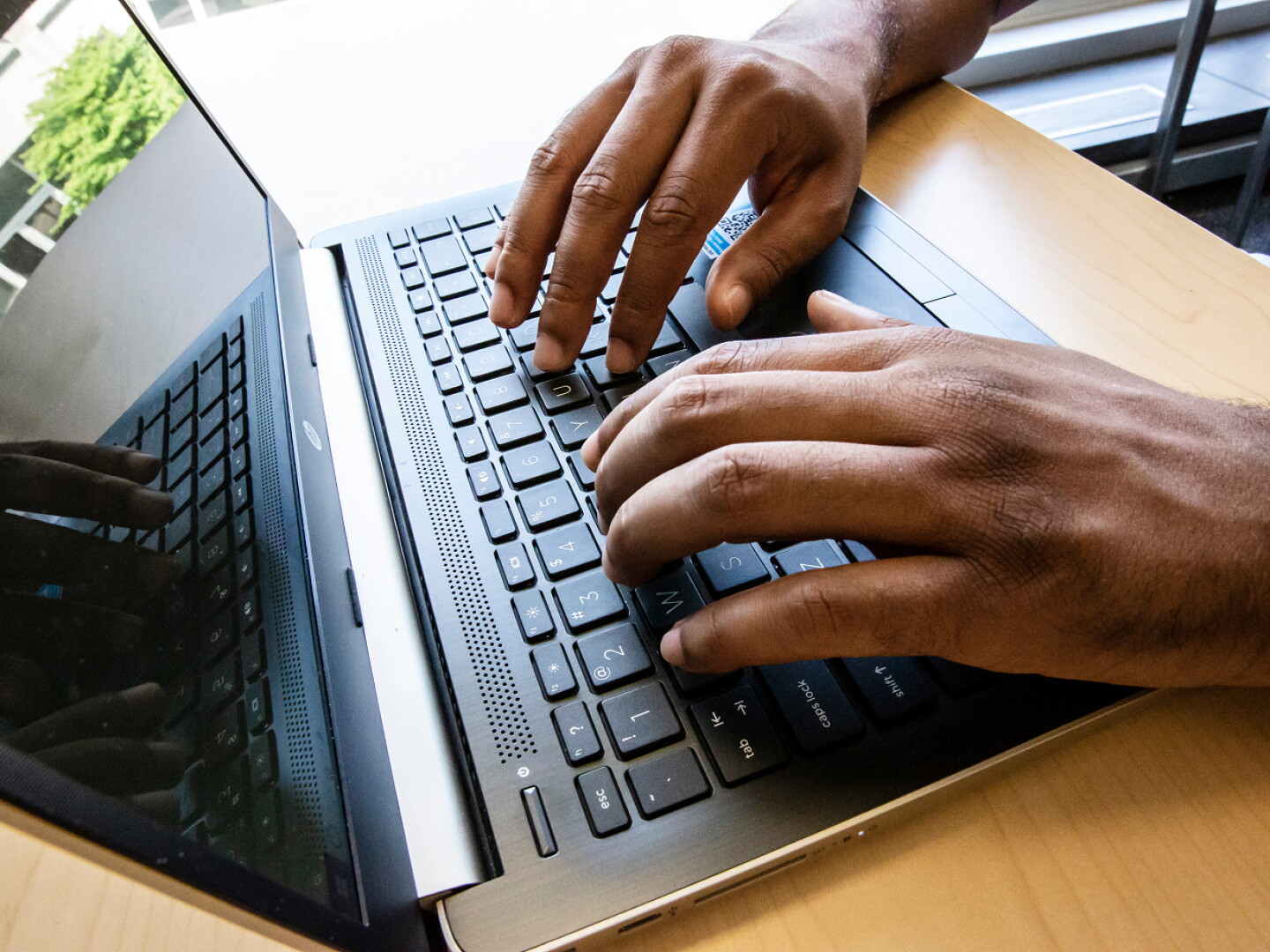 Close-up of hands typing on a laptop