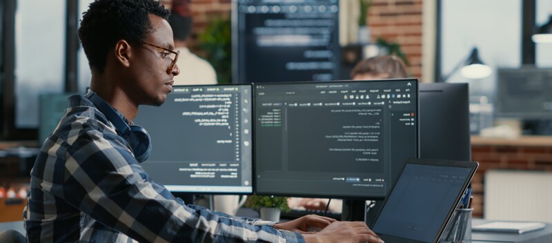 Man on computer typing code