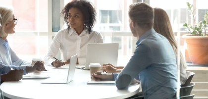 HR professionals sit around a table in a meeting
