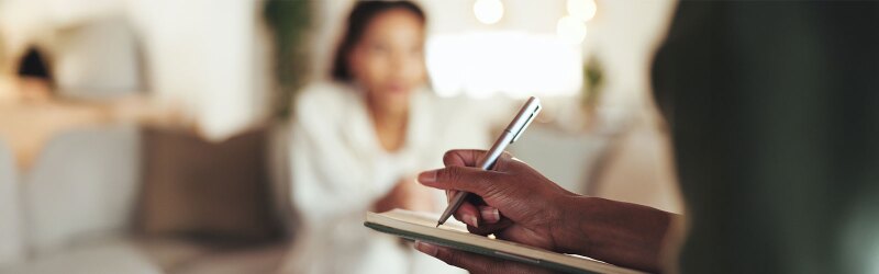 mental health professional taking notes during session with patient