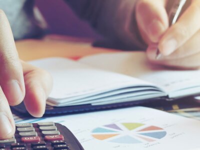 Close up hand man doing finance and calculate on desk about cost at home office.