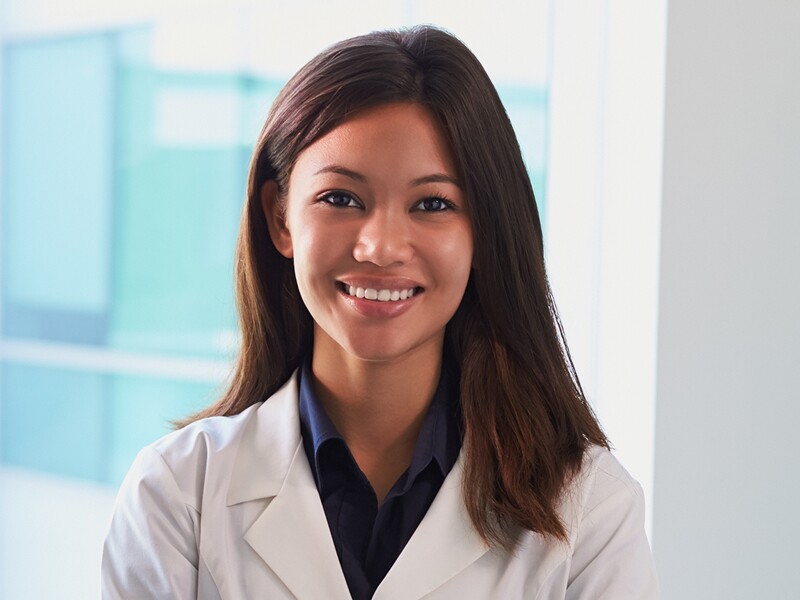 Female doctor wearing white coat in exam room