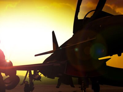 Silhouette of two military personnel working on a fighter jet at sunset, representing aviation maintenance and military operations
