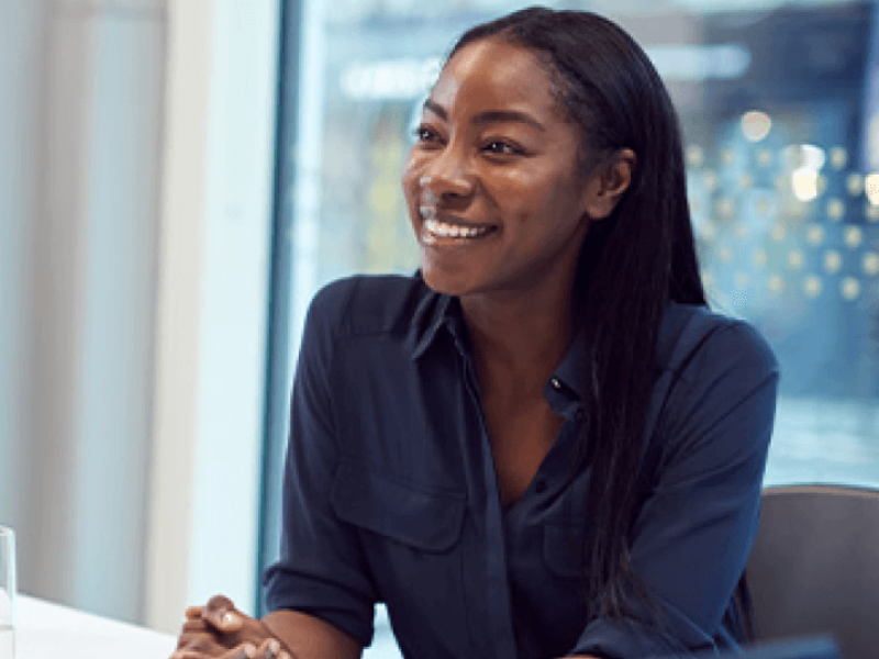 Woman in blue shirt smiling in office