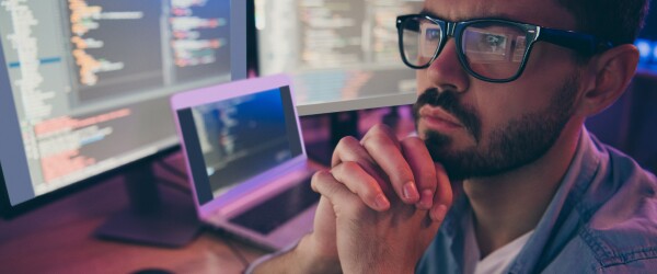 Male professional reviews code on screen