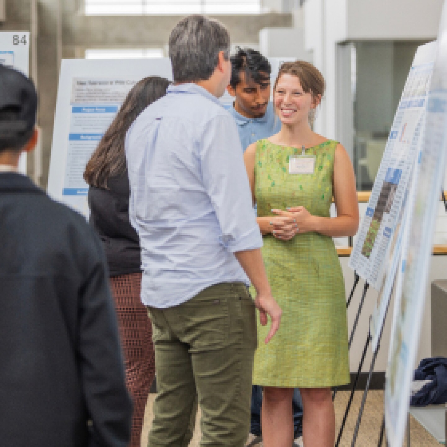 A female student presents a capstone project to an event attendee.