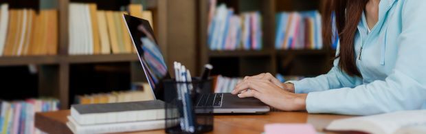 person sitting and typing on a laptop