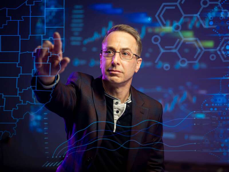 Man in glasses interacting with touchscreen map