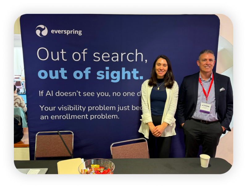 Two people standing at an Everspring booth with banner reading “Out of search, out of sight,” about AI visibility and enrollment.