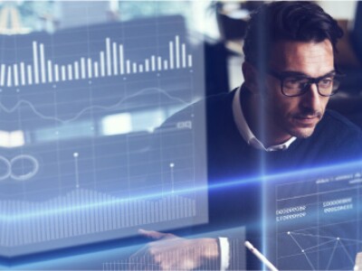 Man in sweater stars at superimposed business data sets