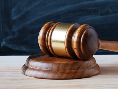 Judge's gavel on a desk in front of a blackboard
