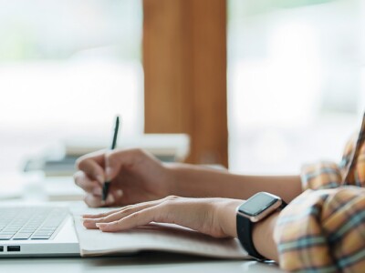 Graduate student writing at a desk