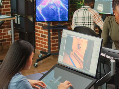 Diverse team of colleagues working on 3d engineering with multiple monitors.